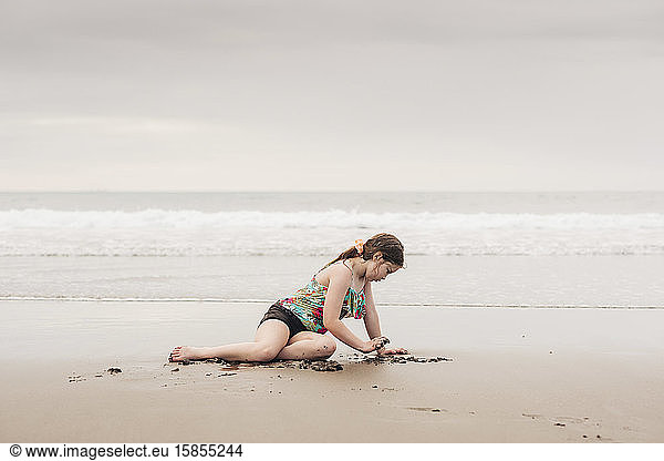 Young girl playing in the sand at the beach