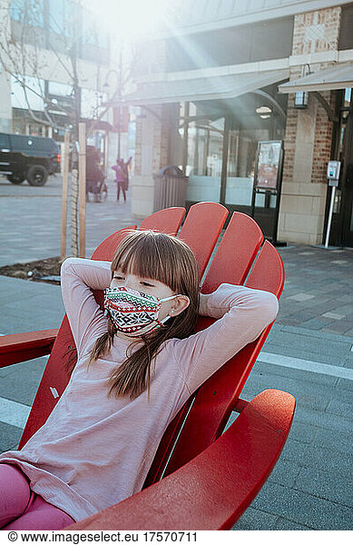 Young girl relaxing outside with mask on