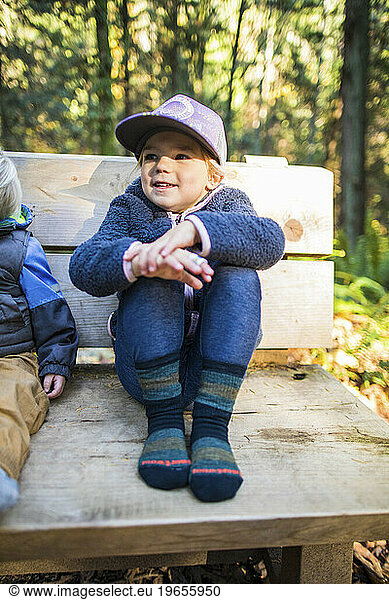 Young girl sits on bench wearing cozy socks