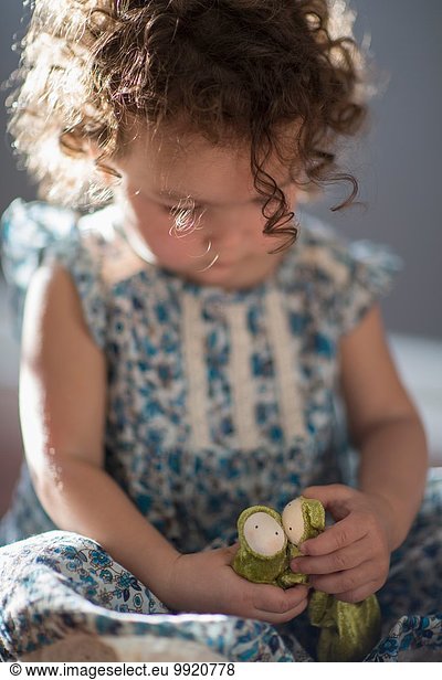 Young girl  sitting on floor  playing with toy