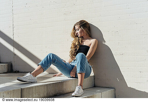 Young Girl Sitting On Stairs Outdoors.