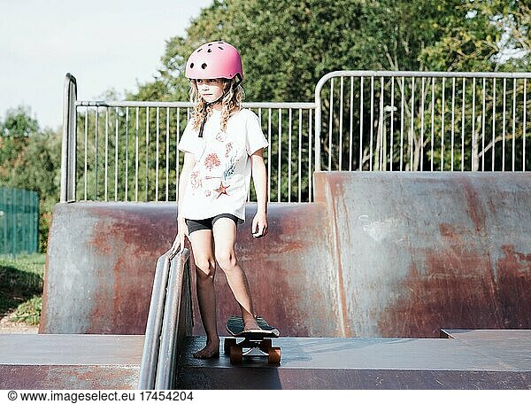 young girl skateboarding at an urban skatepark