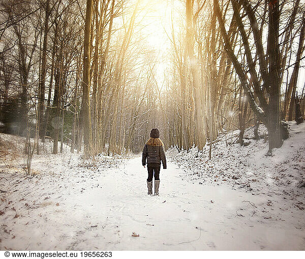 Young girl standing on snowy trail in winter