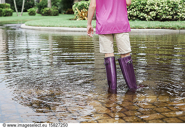 Young Girl Wearing Purple Boots in Water