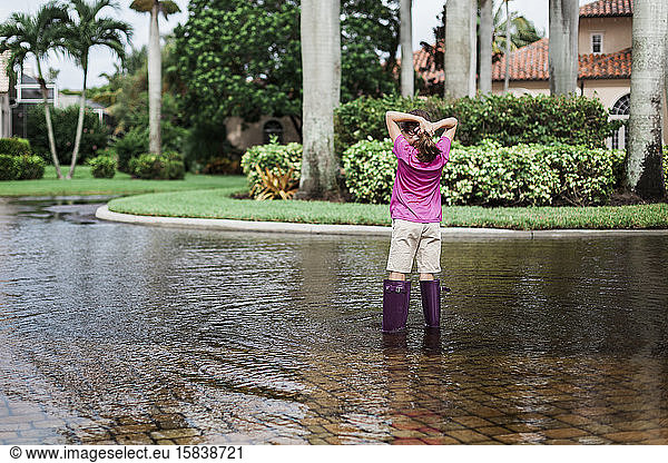 Young Girl Wearing Purple Boots in Water