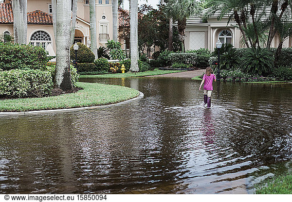 Young Girl Wearing Purple Boots Walking in Water