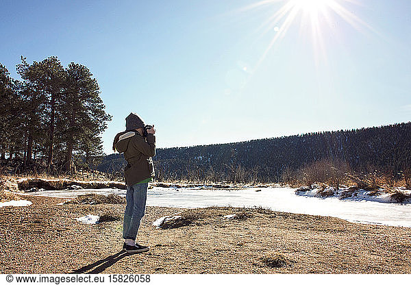Young Girl With Camera Exploring in Rocky Mountains