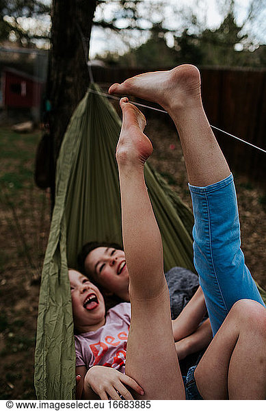 Young girls laying in hammock playing with feet