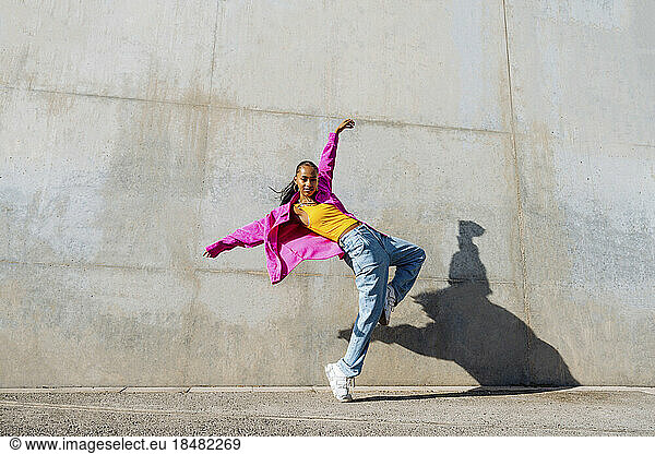 Young hip hop dancer dancing in front of wall