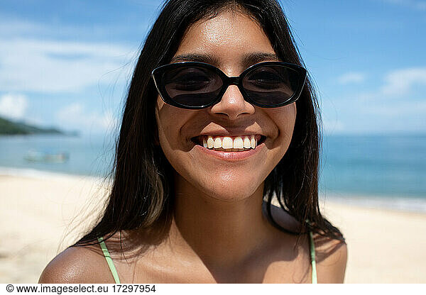 Young Latina woman smiling on beach