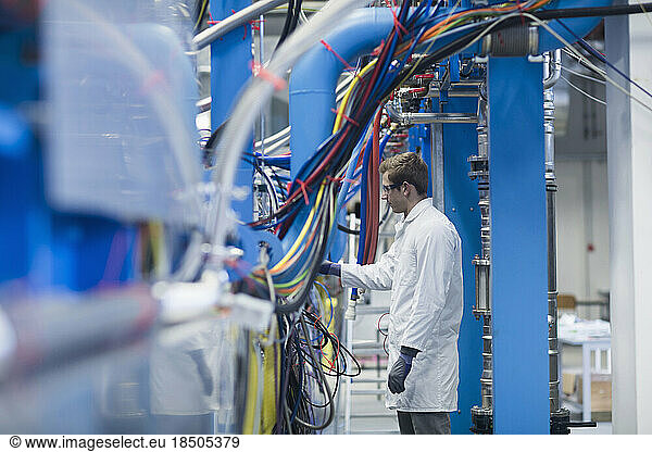 Young male engineer examining machine in an industrial plant  Freiburg Im Breisgau  Baden-Württemberg  Germany