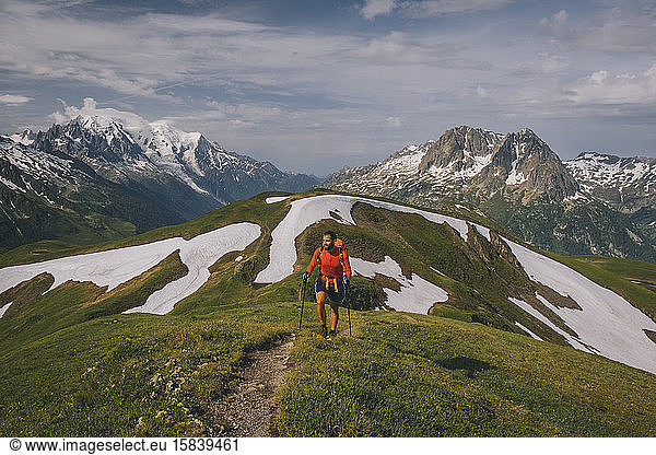 Young male hikes in the French Alps with Mont Blanc as a backdrop.