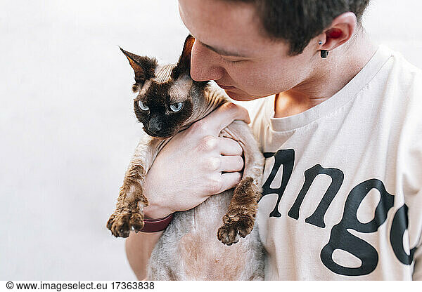 Young male owner holding cat