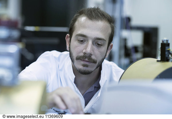 Young male scientist working in technology space