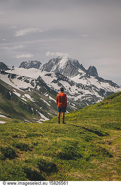 Young male stands looking at the Mont Blanc massif  Chamonix  France.