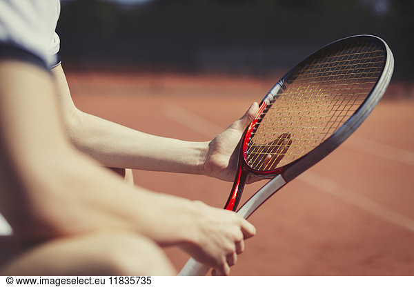 Young male tennis player holding tennis racket