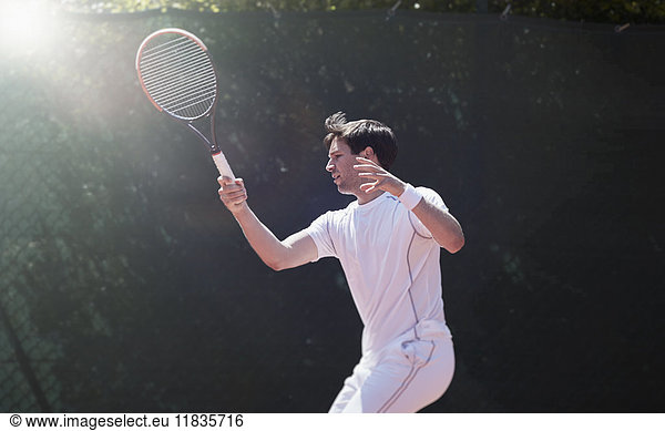 Young male tennis player playing tennis  swinging tennis racket