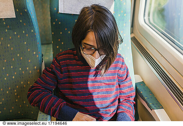 Young male tourist wearing mask travels by train