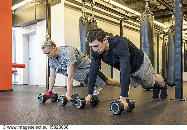 Young man and woman exercising in a gym