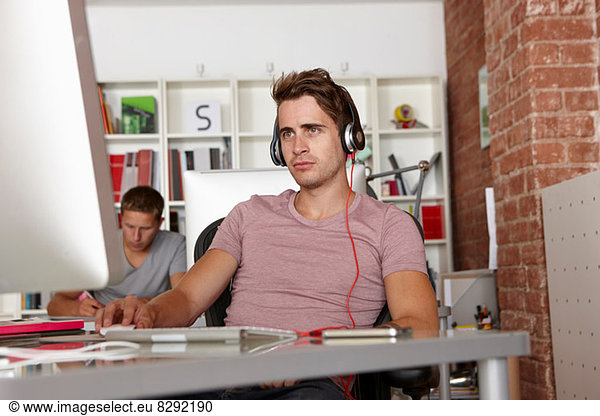 Young man at work wearing headphones