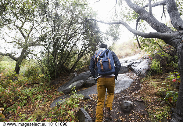Young man carrying a backpack hiking.