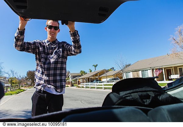 Young man closing car boot  Upland  California  USA