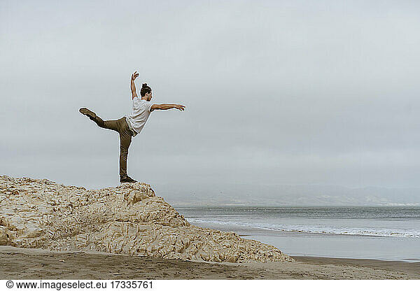 Young man dancing on rock at beach in Point Reyes  California