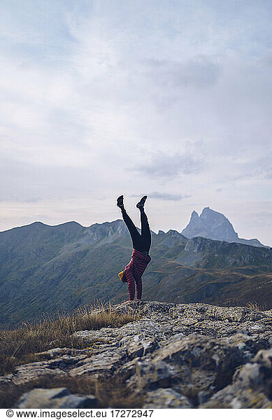 Young man doing handstand on mountain around Ibones of Anayet