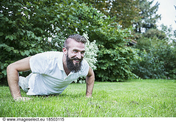 Young man doing push-ups in garden  Bavaria  Germany