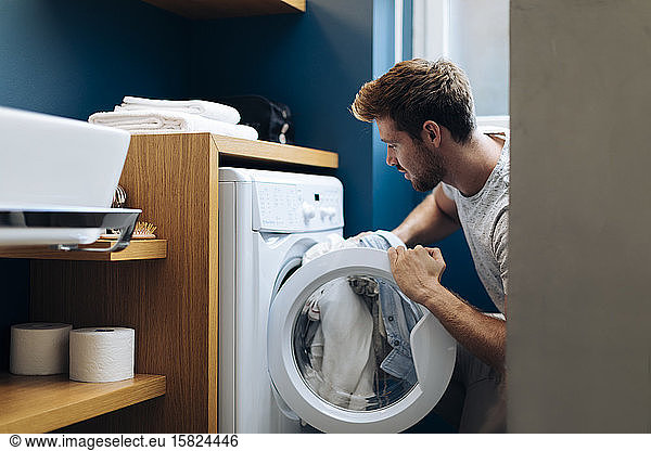 Young man doing the laundry at home