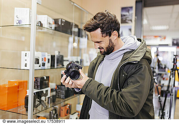 Young man examining camera in store