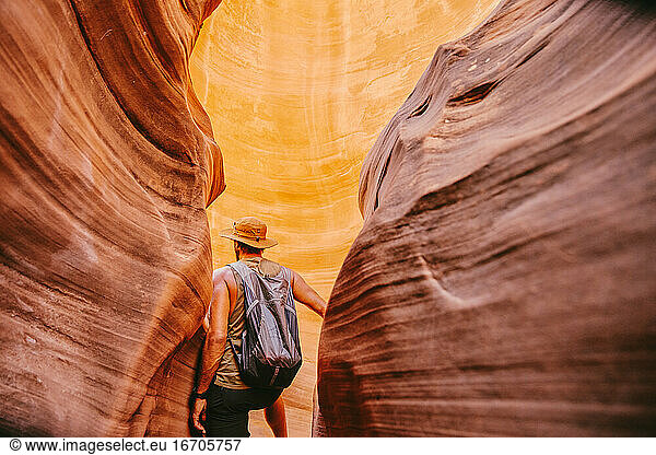 Young man exploring narrow slot canyons in Escalante  during summer