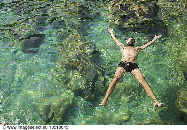 Young man floating on water in sea