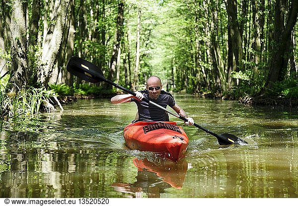 Young man in a red canoe in the Spreewald area  Luebbenau  Brandenburg  Germany  Europe