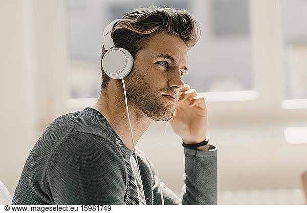 Young man in office wearing headphones