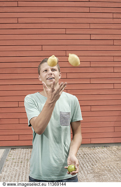 Young man juggling with lemons