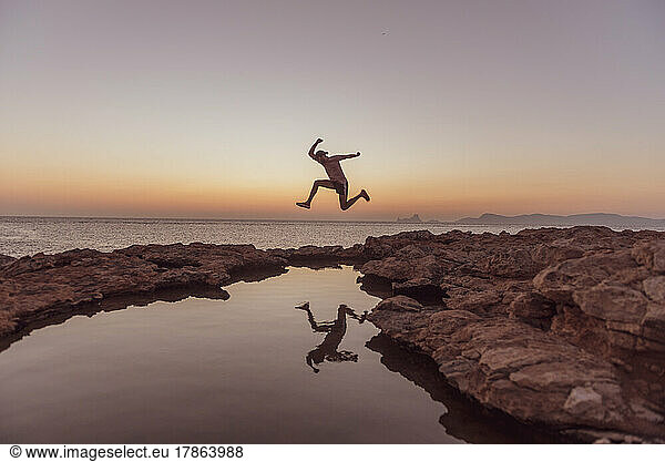 Young man jump the Sunset in Can Marroig in Formentera  Spain