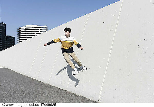 Young man jumping on the urban wall background