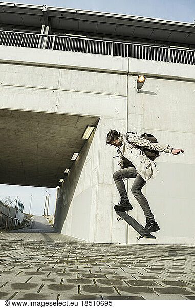 Young man jumping with skateboard in mid-air  Munich  Bavaria  Germany