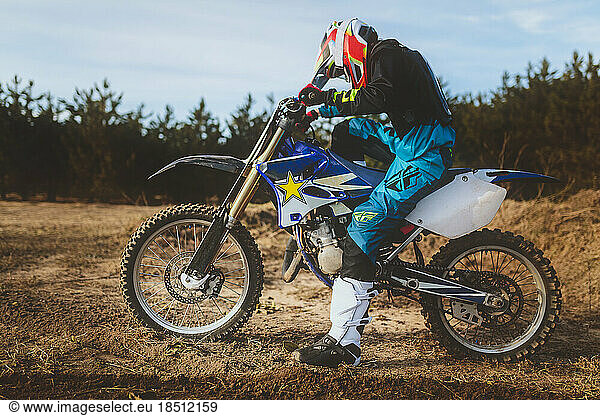 young man kickstarting motocross bike