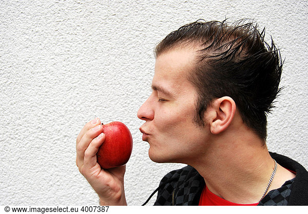 Young man kissing a red apple  love of healthy eating