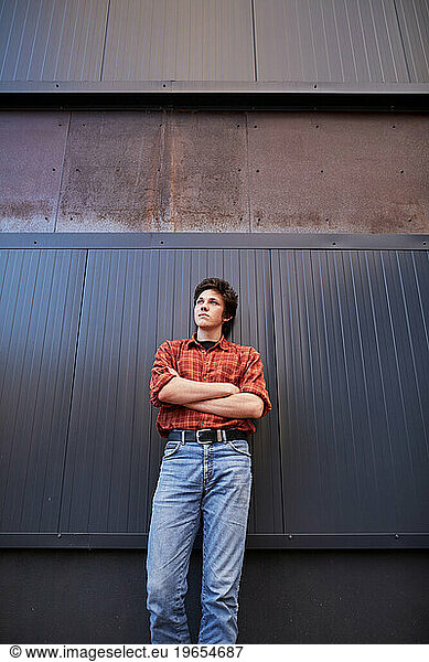 young man leaning against a wall