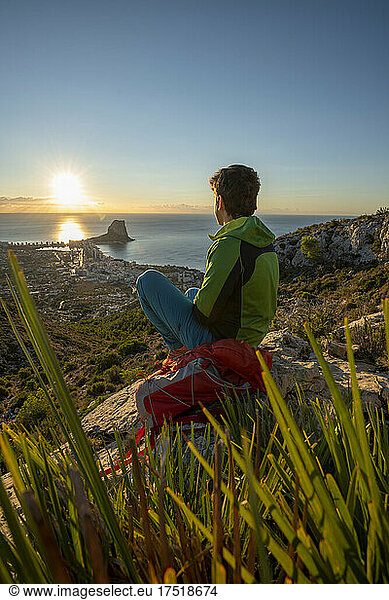 Young man looking at dawn over rocky landscape ,  Calpe,  Costa Blanca