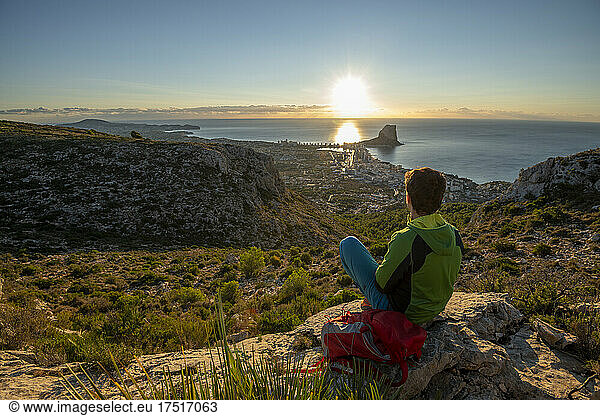 Young man looking at dawn over rocky landscape   Calpe  Costa Blanca