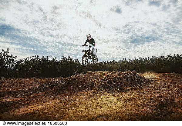 Young Man on Dirt bike jump in blue sky