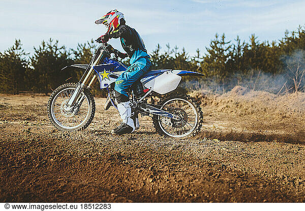 young man on dirt bike roosting tire