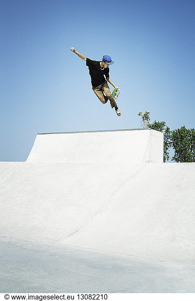 Young man performing stunts on skateboard