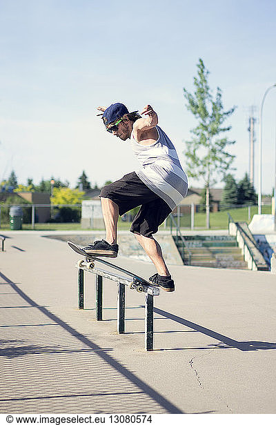 Young man skateboarding on railing