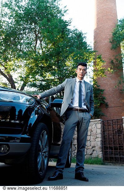 Young man standing by car