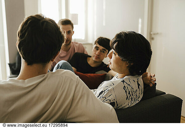 Young man talking with friends while being comforted at home